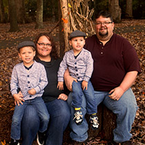 photo of family sitting together on tree stump