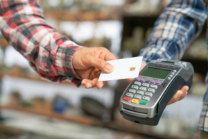 A customer tapping a chip card on a card reader. A customer tapping a chip card on a card reader.